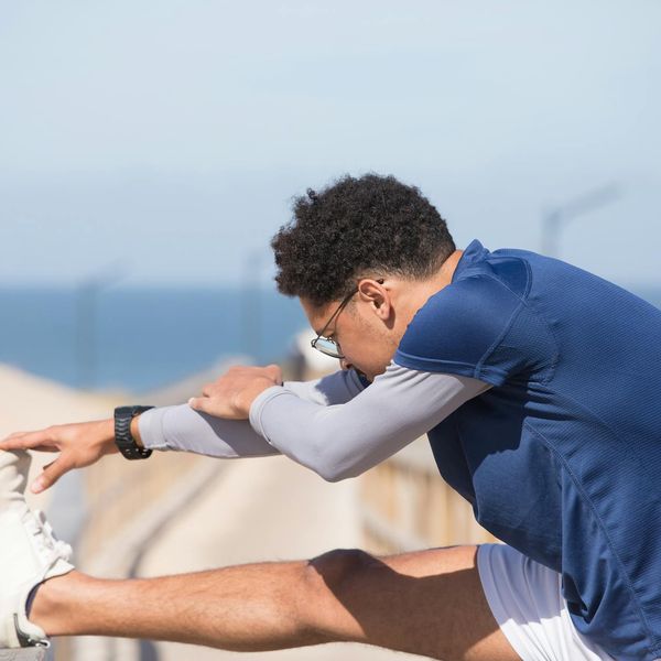 Runner stretching on a track, showing flexibility in motion.